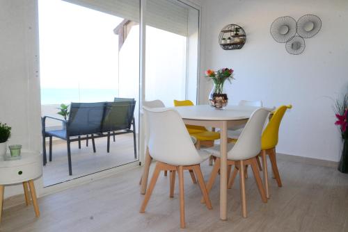 a dining room with a white table and chairs at la perle de martil in Martil