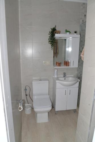 a white bathroom with a toilet and a sink at la perle de martil in Martil