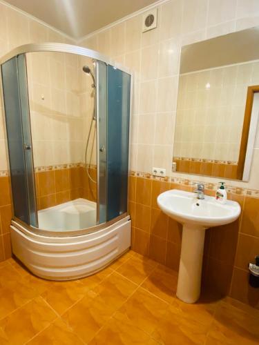 a bathroom with a shower and a sink and a shower at В центрі міста класні апартаменти! in Cherkasy