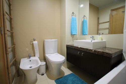 a bathroom with a white toilet and a sink at Angel's Apartment in Funchal