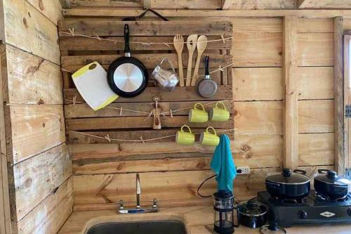 a kitchen with a wooden wall and a sink at Un refugio en las montañas de Tabio in Tabio