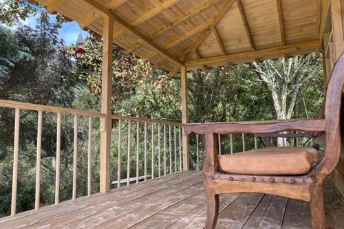 a wooden porch with a chair on a wooden deck at Un refugio en las montañas de Tabio in Tabio