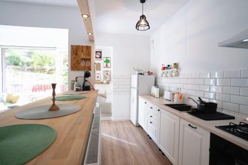 een keuken met witte kasten en een houten aanrecht bij Bubbles studio Sinaia with terrace in Sinaia