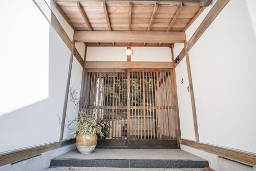 a entrance to a building with a wooden door at プライベートリゾート 月灯 in Atami