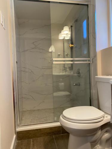 a bathroom with a toilet and a glass shower at Richmond Vancouver Airport Comfy Home in Richmond