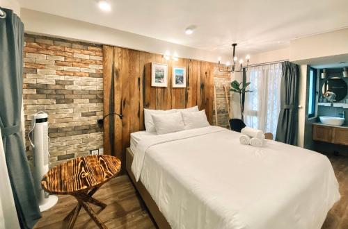 a bedroom with a white bed and a brick wall at Petite Dalat - Boutique Hotel in Da Lat