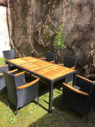 a wooden table and four chairs around a wooden table and chairs at ALTSTADT-APARTMENTS Bad Radkersburg - Ihr Zuhause auf Reisen in Bad Radkersburg
