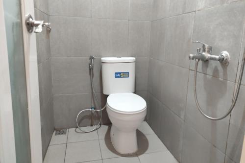 uma casa de banho com um WC e um chuveiro em RedDoorz near Agrowisata Kebun Teh Dieng em Wonosobo