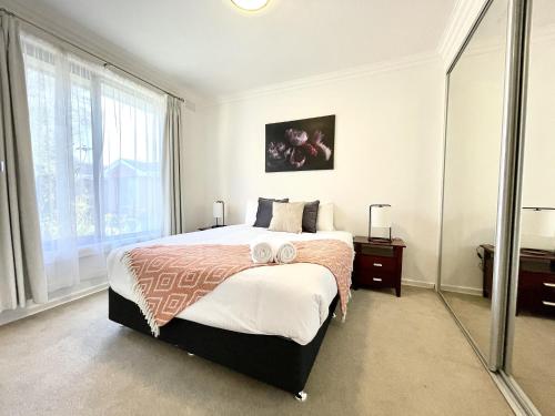 a bedroom with a large bed with two towels on it at Brighton Villas by Readyset in Melbourne