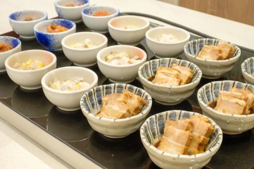 un montón de tazones de comida en una mesa en Richmond Hotel Naha Kumoji, en Naha
