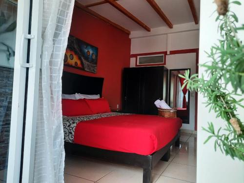 a red bedroom with a bed with a red bedspread at Hotel & Suites Cerro Roj0 in Tlatlauquitepec