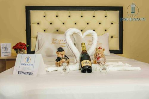 een bed met 2 flessen champagne en zwanen handdoeken bij Hotel Jose Ignacio Chepen in Chepén