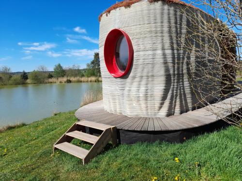 a barrel with a red window sitting next to a body of water at Residence Safari resort - Prvok in Borovany