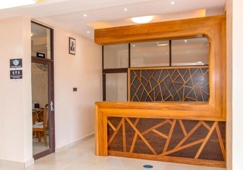 a wooden pivot door in a room with a glass at Hotel Comster Mtwapa in Mtwapa
