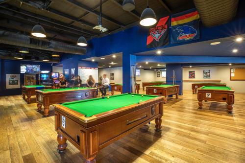 a billiard room with several pool tables in it at Nightcap at Sandown Park Hotel in Noble Park