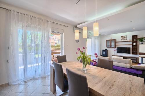 a dining room and living room with a table and chairs at Apartments Meštrović with heated swiming pool- near Split in Kaštela