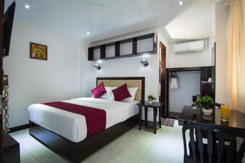 een hotelkamer met een bed en een bureau bij Diamond Hotel And Resto in Catarman