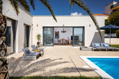 un patio trasero con piscina y una casa en Belvedere Holidays Villas, en Novigrad Istria