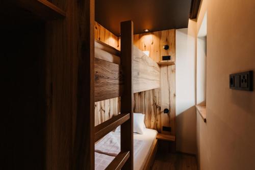 a bunk bed in a room with wooden walls at Hoamat House I Boutique Apartments in Sankt Margarethen im Lungau