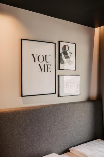 three framed pictures on a wall above a bed at Hoamat House I Boutique Apartments in Sankt Margarethen im Lungau