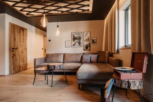 a living room with a couch and a table at Hoamat House I Boutique Apartments in Sankt Margarethen im Lungau