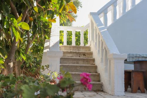 un escalier avec une balustrade blanche et une fleur rose dans l'établissement Masseria Piccola Convertino by Apulia Hospitality, à Faccia di Trippa