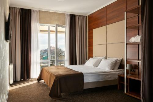 a hotel room with a bed and a large window at Optima Collection Gallery Poltava in Poltava