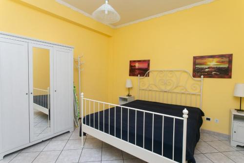 um quarto com uma cama e uma parede amarela em M116 - Marcelli, bilocale in centro e fronte mare em Marcelli