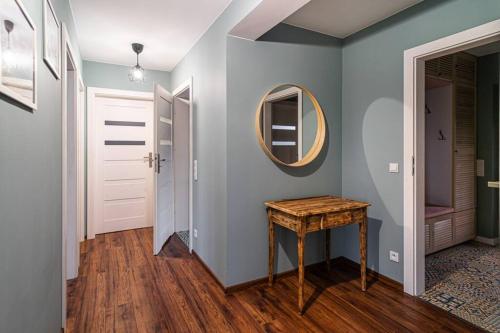 a hallway with a table and a mirror at Willa Spokojne Wzgórze in Pławna