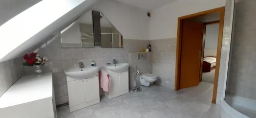 a bathroom with two sinks and a toilet at Baranie Wzgórze Ustroń Basen Sauna Plac Zabaw in Cisownica