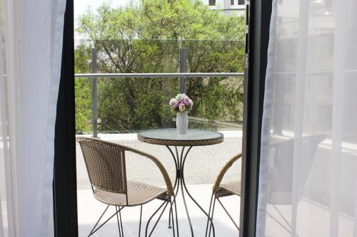 a table with chairs and a vase of flowers on a patio at Gamalan Spring Hotel in Jiaoxi