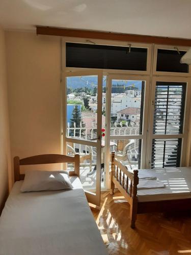 Un dormitorio con dos camas y una gran ventana. en Apartment Danilo, en Herceg-Novi