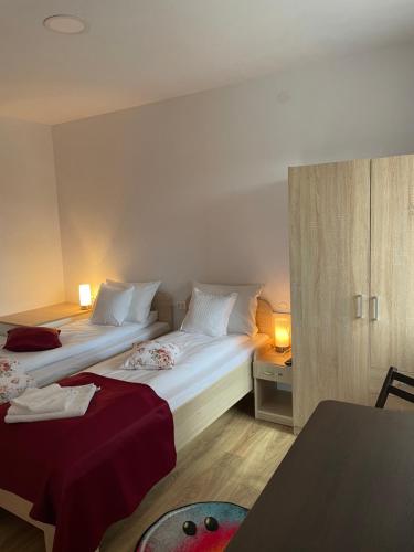 a hotel room with two beds and a table at Gizella vendégház in Odorheiu Secuiesc