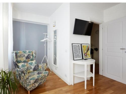 a living room with a chair and a tv at Ca' Cornello in Calco