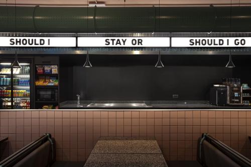 a counter in a store with a sign that reads stay orstay at Stay Hotel in Brunello