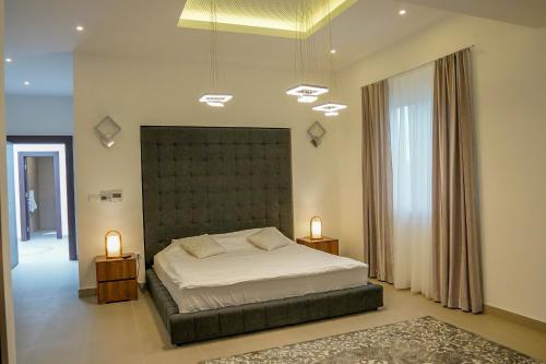 a bedroom with a large bed and two lamps at Al Hayat Apartments in Vogošća