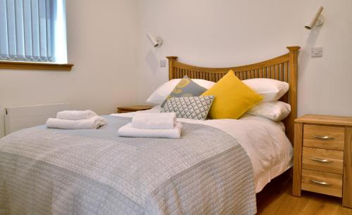 1 dormitorio con 1 cama con toallas en Blue Watch en Lochaline