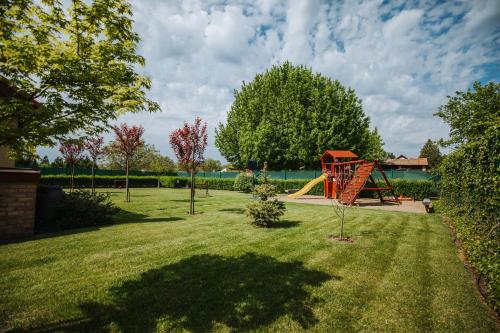 a playground with a slide in a yard at Németh Apartmanházak in Mórahalom