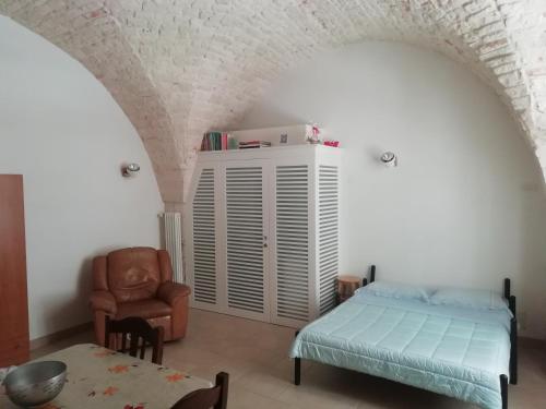 a bedroom with a bed and a chair and a table at Casa Vacanze Giovanni Cesare in Noci