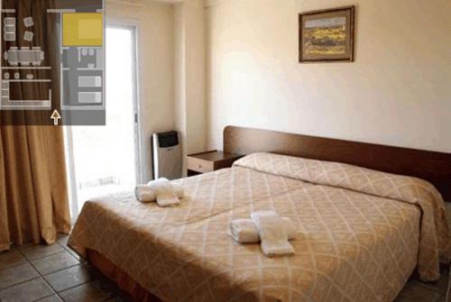 1 dormitorio con 1 cama con toallas en Wilson Apart Hotel en Salta