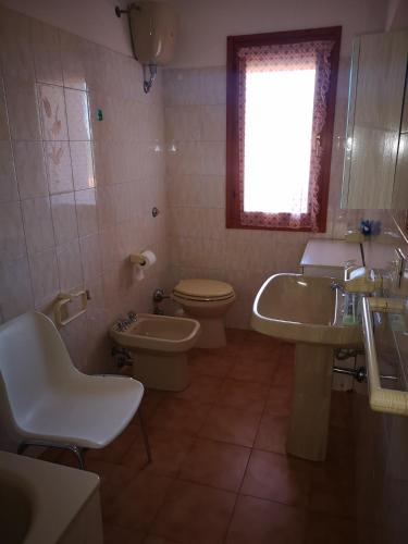 a bathroom with a sink and a toilet and a window at Casa Adriana in Alghero