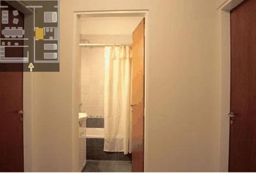 pasillo con baño con cortina de ducha en Wilson Apart Hotel en Salta