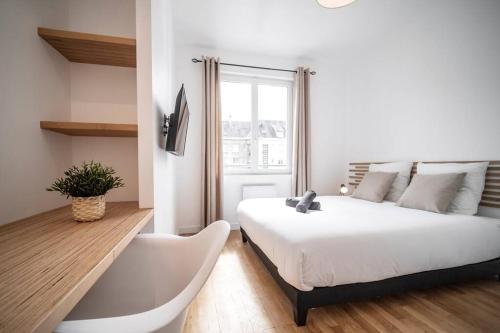 - une chambre blanche avec un lit et une baignoire dans l'établissement APPT VUE SUR LE PORT DE CAEN/ CENTRE VILLE PREMIUM, à Caen