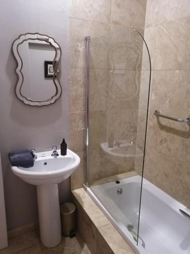 a bathroom with a sink and a glass shower at Ceres Cozy Cottage in Ceres