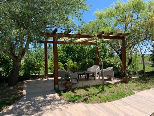 a wooden pergola with a table and chairs on a deck at Affitta Camere "Le Quercigliole" in Ripalimosani
