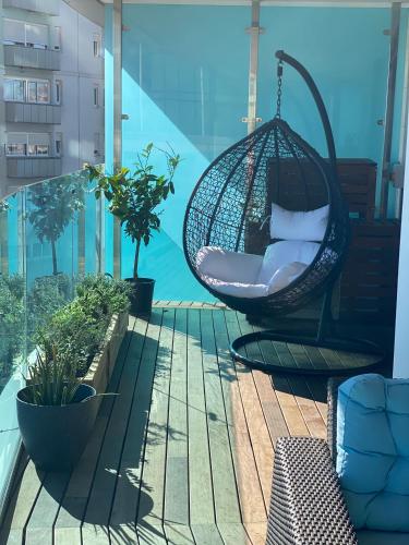 a hammock on a balcony with a view of the water at Luxury Ocean Spa Plaza Private Large 1 bed apartment in Gibraltar