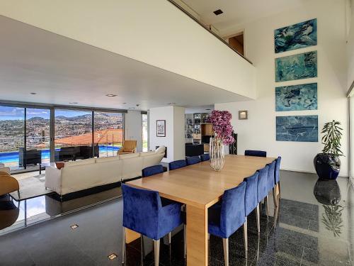 a dining room with a table and blue chairs at The White House - By LovelyStay in Funchal