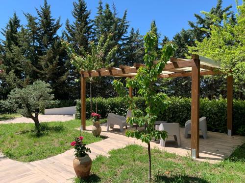 a wooden pergola with white chairs and a table at Affitta Camere "Le Quercigliole" in Ripalimosani