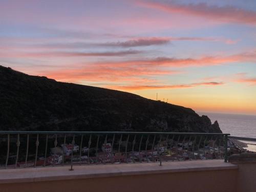 a view of the ocean from a balcony at sunset at Buggerru a Mare Residence in Buggerru