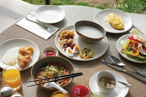 a table with plates of food on top of it at VALA Hua Hin - Nu Chapter Hotels in Cha Am